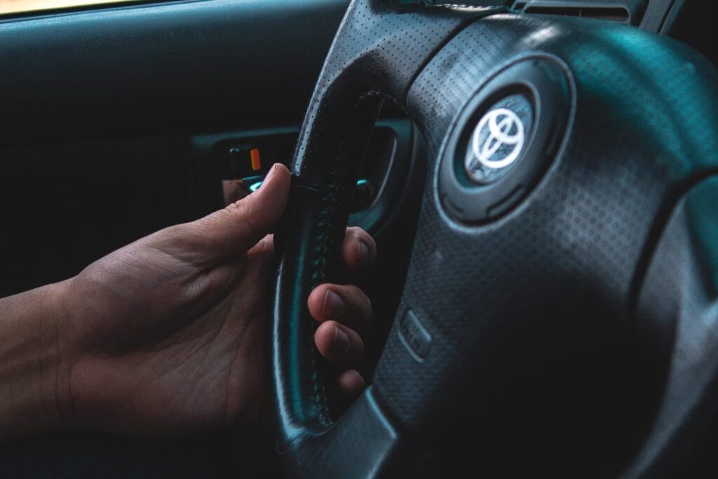 Toyota-steering-wheel - Ferraro Law Firm driver's hand on Toyota steering wheel